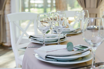 Glasses for wine and champagne on a served table at banquet. Wedding decoration.
