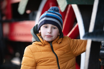 Portrait of an eight year old boy in a jacket and hat.