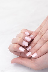 Pink colored nails on woman hands with copy space