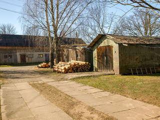 picture with a farm barn and prepared firewood for the winter