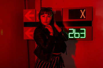 Female Model with blue hair in red light posing in front of parking lot counter