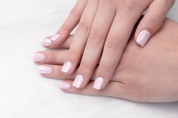 Woman hands with colored nails above white background