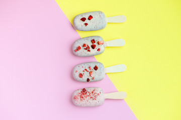 Eskimo ice cream in white chocolate glaze with red sprinkles on pink background. Yummy sweet food snack treat. Top view.