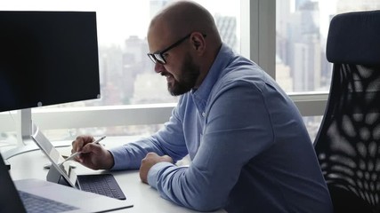 Experienced workaholic creating project after dawned idea using stylus pen and 4g wireless on modern digital tablet for browsing internet, successful male professional working productive
- Powered by Adobe