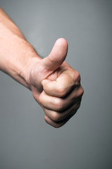 A close up  of a male's hand signaling a Thumbs Up.