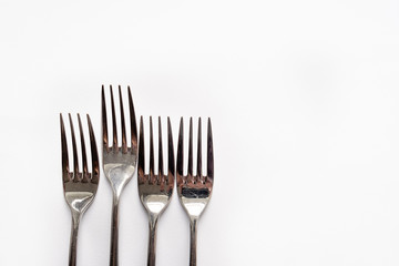 four forks lie on a white background