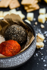 Close-up of two soft cheese balls labne with spices on wooden board.