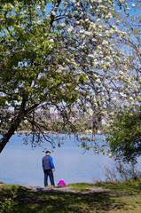 Father walks with his daughter in a park near the river
