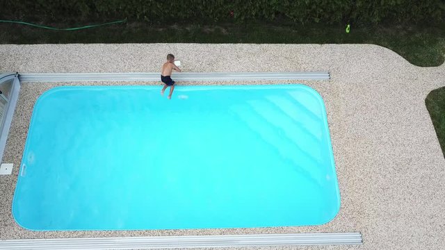 Little boy is playing in a home swimming pool.
Aerial view of a child enjoying the summer weather on the water.
