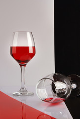 Two glasses of red wine on a glossy white table