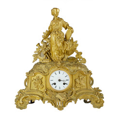 Vintage antique golden table clock. Bronze fireplace watch in gilding isolated on white background. Quartz watch with a sculpture of a girl.