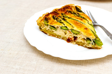 Tart with green asparagus and toasted cheese on the table