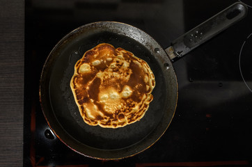Pancakes are fried in a pan on an induction stove	