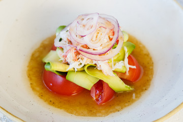 Fresh salad with crab meat and avocado in a plate.