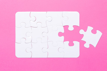 Last piece jigsaw White puzzle Concept success of business Pink background Top view