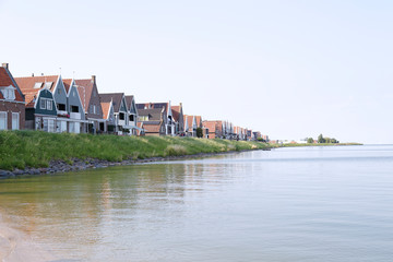 Fototapeta na wymiar Classic homes aligned along the shore of the North Sea, Volendam, The Netherlands.seashore