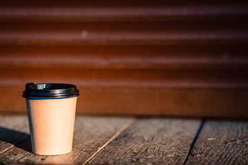 Cup coffee and hot coffee over floor wooden on dark background in sunlight / selective focus, copy space.
