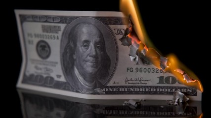 Us dollar bill money is on fire on black background, large frame, concept of global financial crisis and inflation.