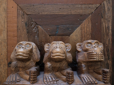 Statuette des trois  singes sages sur une vieille table en bois. 