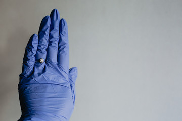 Female hand with blue latex gloves and engagement ring