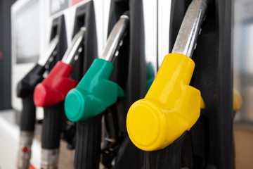 multi-colored clean pistols at a gas station with fuel for cars. Detail of a gasoline pump in a gas...