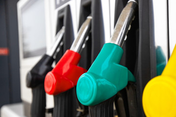 bright new clean pistols at a gas station with fuel for a car. Detail of a gasoline pump in a gas...