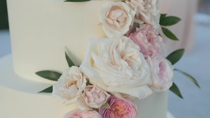 Beautiful white wedding cake with pink flowers rotating gimbal effect
