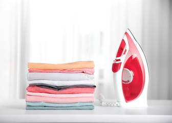 Stack of colorful cotton clothes with iron.Household concept.Stacked laundry.
