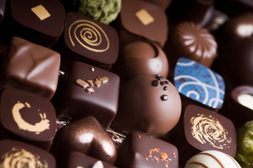 Mixed luxury dark and milk chocolate truffles. Assorted delicious handmade chocolate pralines in a row. Full frame background. Studio shot. Close-up