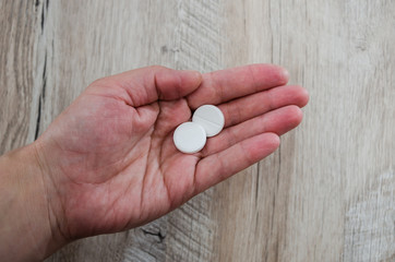 two pills in hand, close-up.