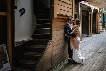 Two lovers stand in an old wooden alley
