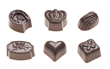Luxury milk chocolate truffles. Assorted delicious handmade pralines in a row isolated on white. Studio shot. Close-up