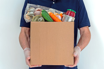 Male volunteer is holding a food donation box for people suffering from the effects of the coronavirus pandemic.