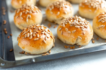 Hot fresh homemade buns sprinkled with seeds. Close-up, selective focus