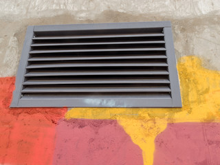 exit of the ventilation grate on the concrete wall of the building