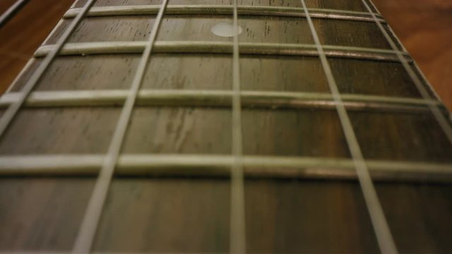 A 4K close up shot of a Banjo, guitar, Musical instrument, strings ready to be picked up and played. Learn a new instrument. Learn something new. Tilting shot close up