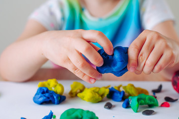 Close up of kids hands molding colorful childs play clay