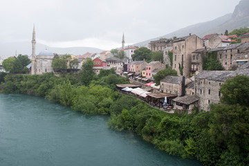 Fototapeta na wymiar Views of Mostar with colored facades and roofs on the banks of the Neretva River in Bosnia, Europe.