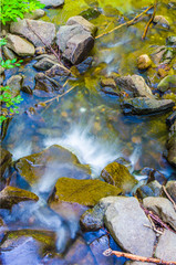 mountain stream waterfall with pure and clear water running fast downstream
