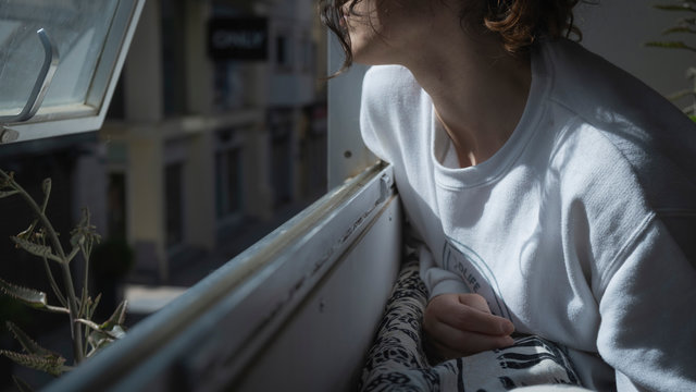 Chica con pelo rizado mirando por la ventana