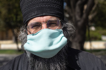 Portrait of an orthodox christian priest monk in a mask. Quarantine in the church