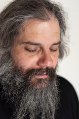 Portrait of a male person, man with beard looking down. Face of sleepy human with closed eyes
