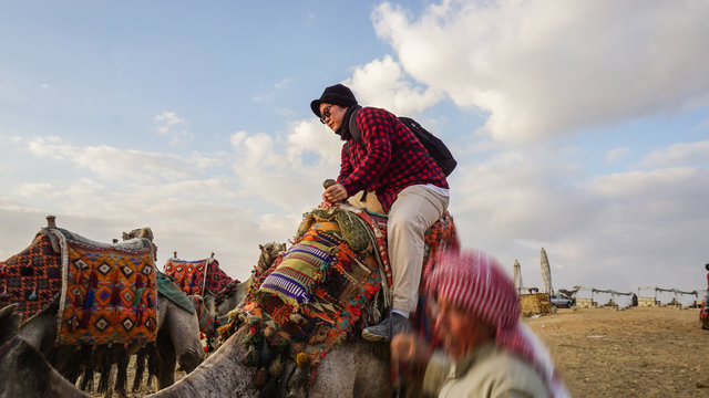 Asian tourist riding camel at pyramid of Giza top hit experience activity in Egypt