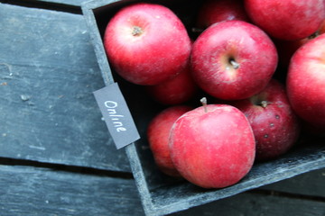Grocery online shop concept. Ripe red apples in wooden box.