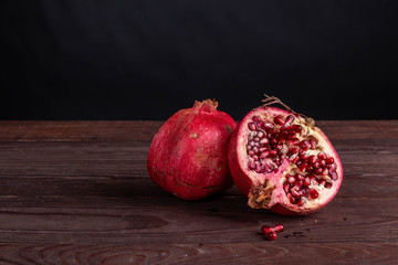 pomegranate on a wooden board on a black background