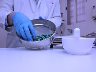 Pharmacist preparing capsules in a pharmacy laboratory