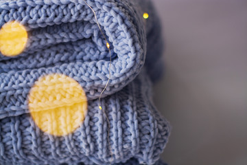 Background or texture of blue hand-knitted plaid and pillows in cosy autumn or winter home.