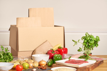 Box with packed meat vegetables on kitchen background. Food delivery services during coronavirus pandemic and social distancing. Shopping online. .Dinner delivery service. - 342086299