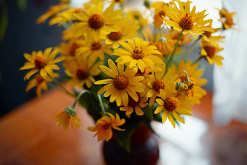 Yellow  flowers in wase  on the table in house 