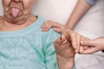 Hands of a 9-year-old grandson with love hugs, cares, helps about his old grandmother of 90 years,...